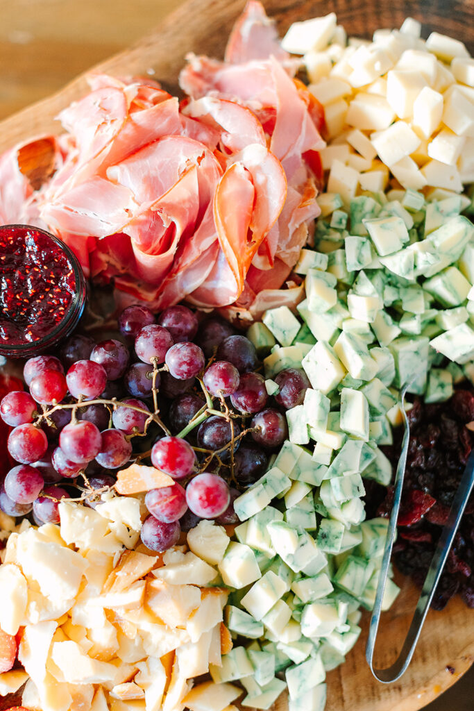 Food Worth Celebrating: Hearty Boys designed an incredible food spread for a Spring wedding complete with grapes, sliced meats and a variety of cheese. by Ashlee Cole Photography
