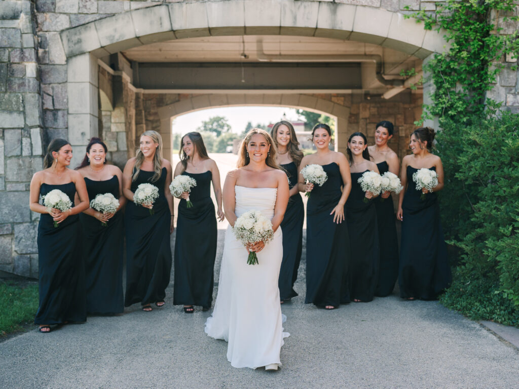 Bride walking with bridesmaids in black dresses at Arrowhead Golf Club wedding, captured by Naperville wedding photographer.